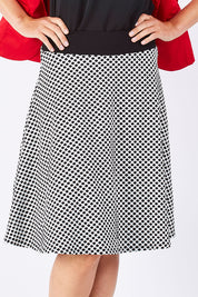 Model Jude wearing size 10 of the Spotted A Line Skirt in colour Spotted (White), from the front, cropped image