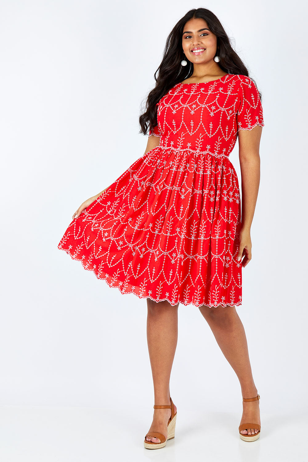 Model Shanaya wearing size 14 of the Printed Fit And Flare Dress in colour Embanglais (Red), from the front, showing the whole outfit