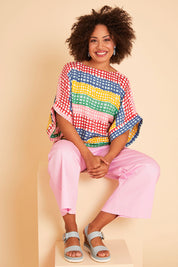 Model Olivia wearing size 10 of the Tie Back Bell Sleeve Top in colour Hopscotch (Pink), from the front, showing the whole outfit