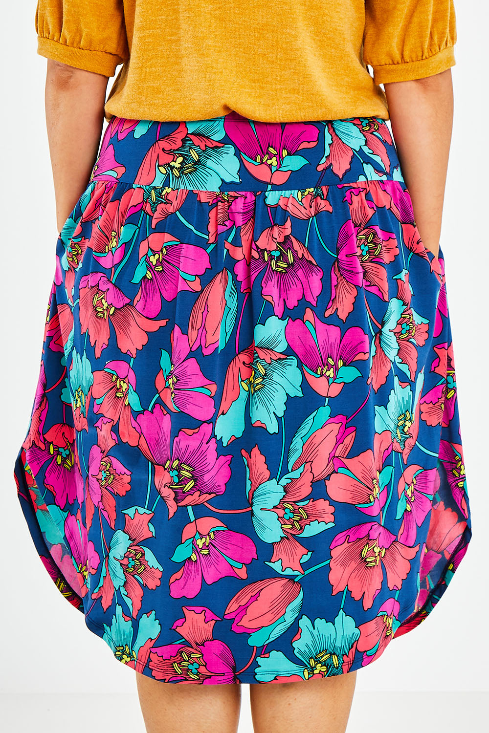Model Jess wearing size 14 of the Elastic Waist Curved Hem Skirt in colour Lilly (Blue), from the back