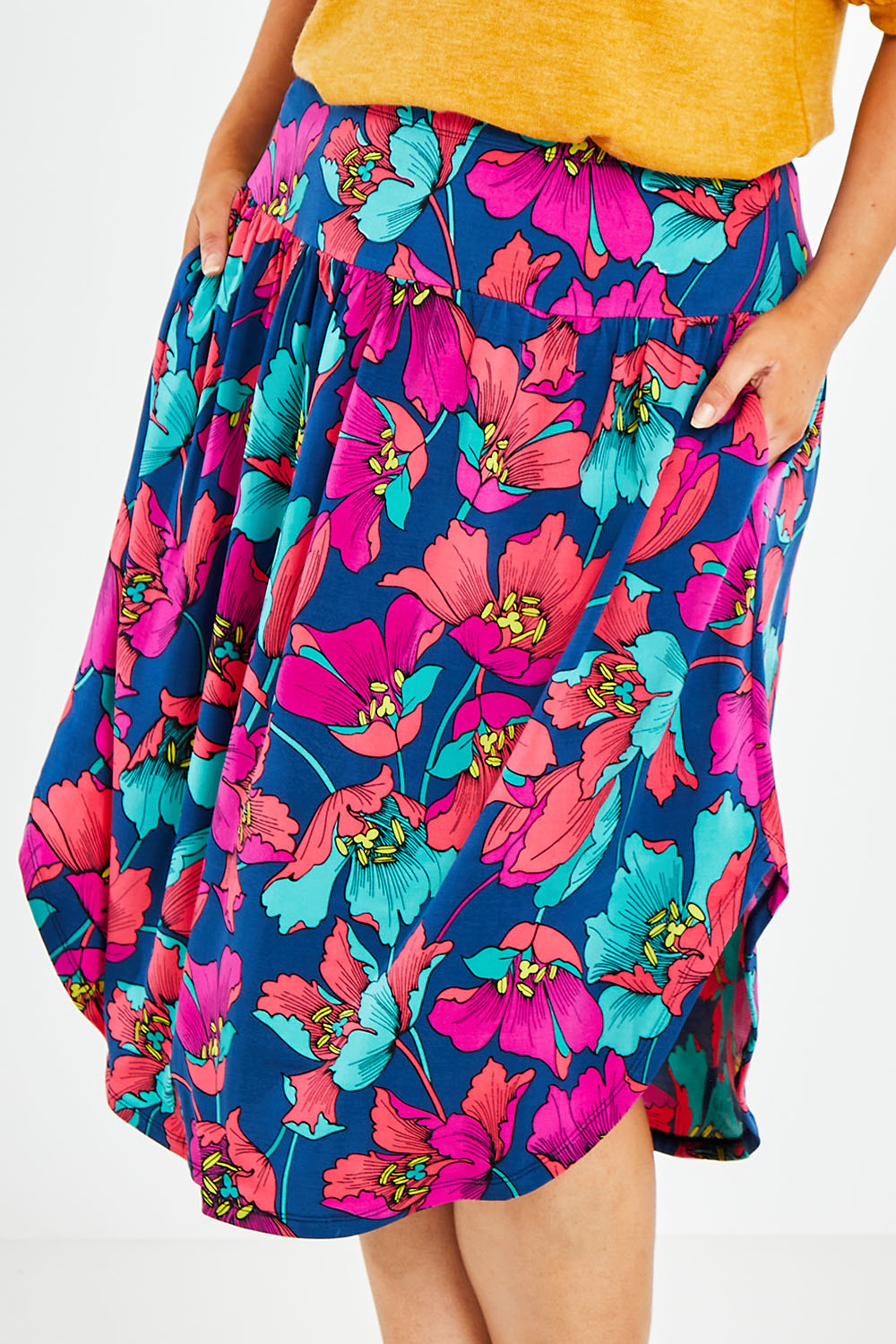Model Jess wearing size 14 of the Elastic Waist Curved Hem Skirt in colour Lilly (Blue), from the front, cropped image