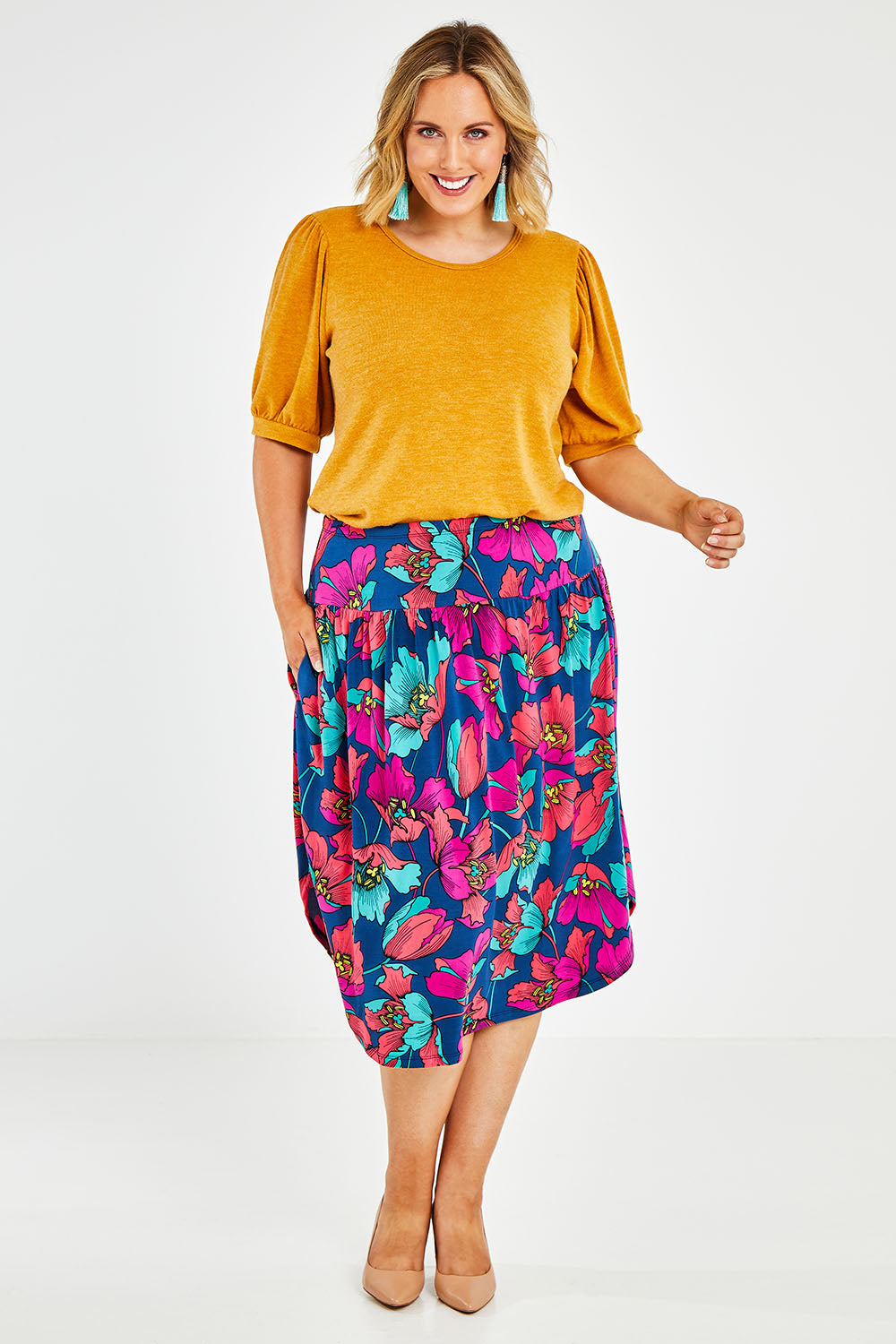 Model Jess wearing size 14 of the Elastic Waist Curved Hem Skirt in colour Lilly (Blue), from the front, showing the whole outfit