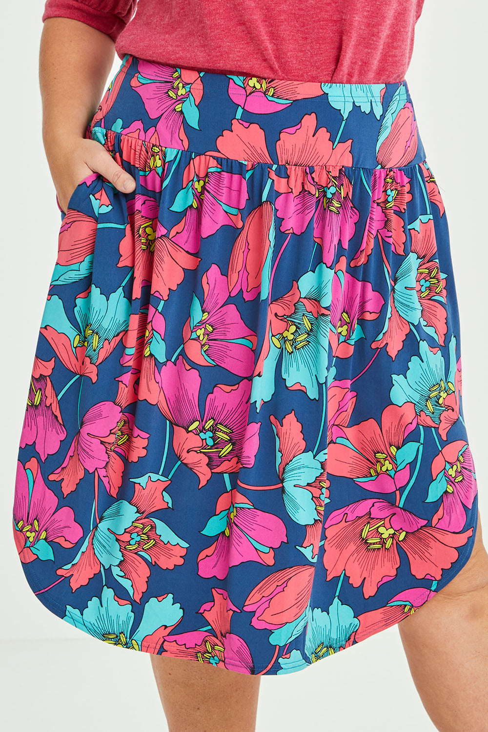 Model Lauren wearing size 16 of the Elastic Waist Curved Hem Skirt in colour Lilly (Blue), from the front, cropped image