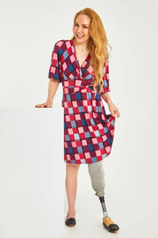 Model Lisa wearing size 10 of the Gathered Waist Faux Wrap Dress in colour Checkered (Red), from the front, showing the whole outfit