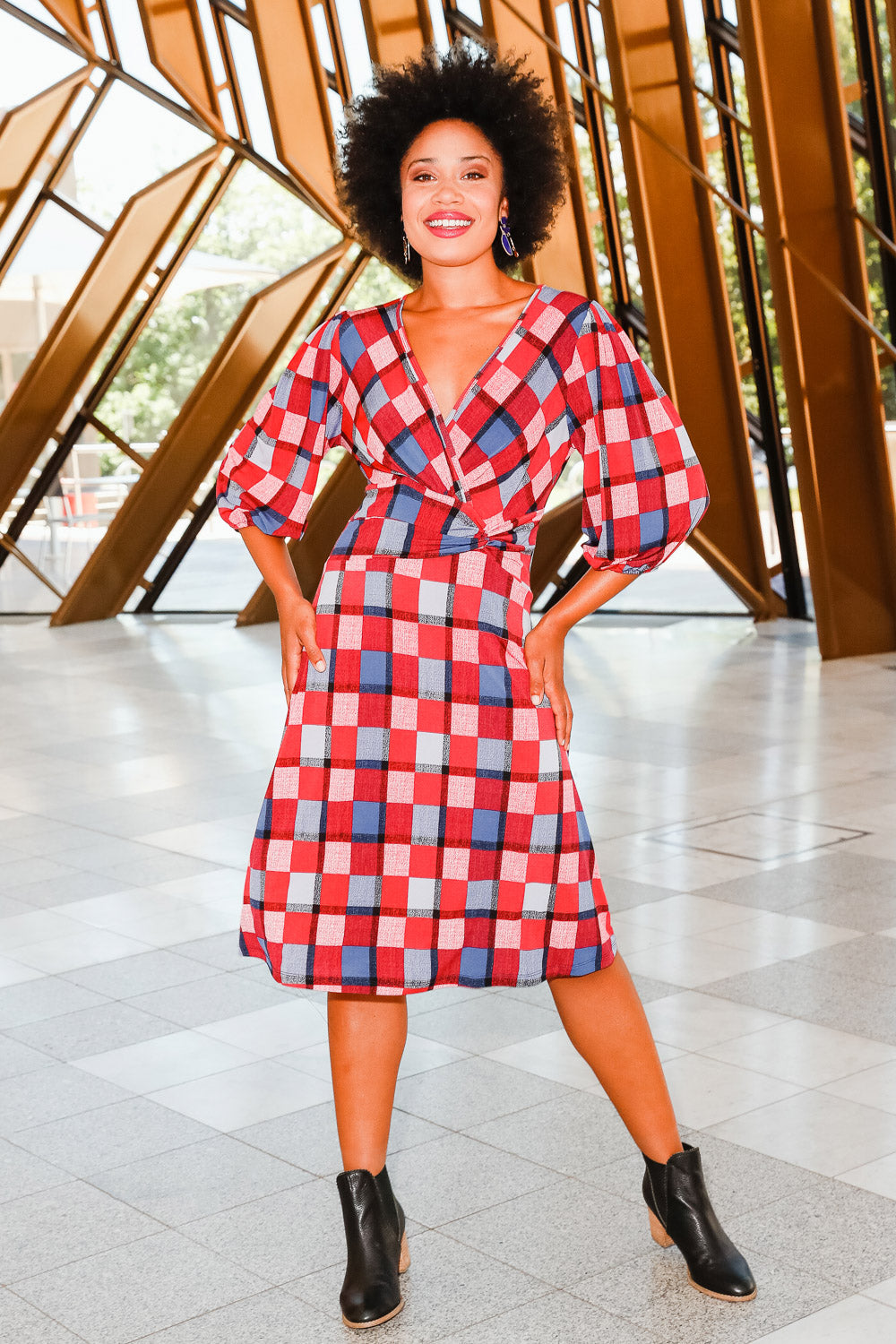 Model Olivia wearing size 10 of the Gathered Waist Faux Wrap Dress in colour Checkered (Red), from the front, showing the whole outfit