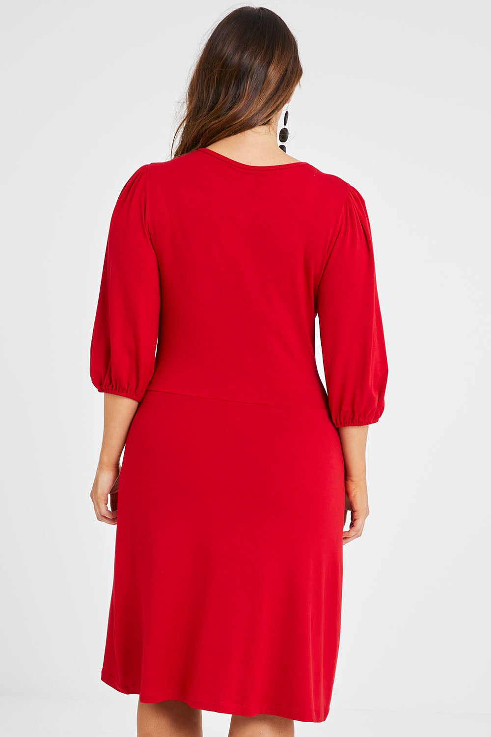 Model Laura wearing size 14 of the Gathered Waist Faux Wrap Dress in colour Flame (Red), from the back