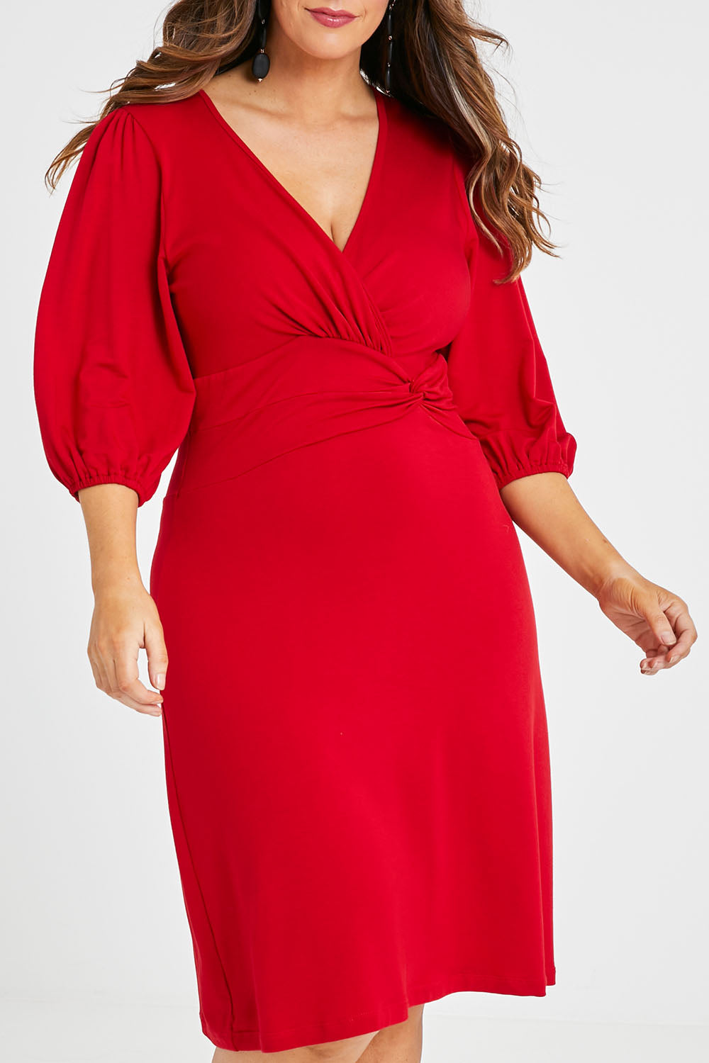 Model Laura wearing size 14 of the Gathered Waist Faux Wrap Dress in colour Flame (Red), from the front, cropped image