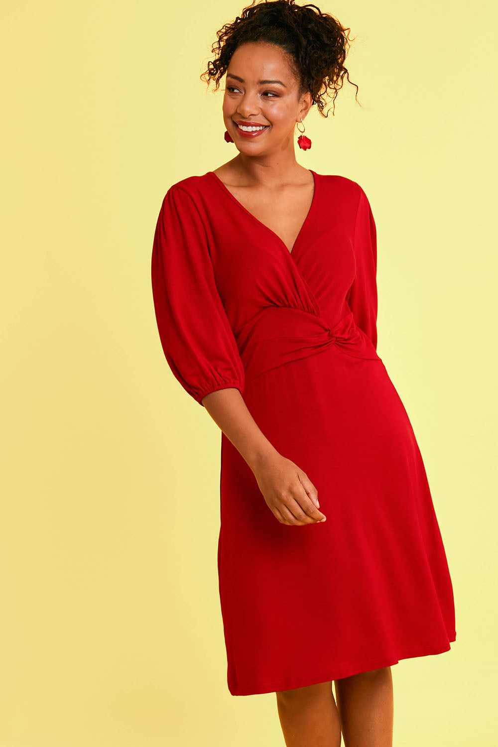 Model Noli wearing size 14 of the Gathered Waist Faux Wrap Dress in colour Flame (Red), from the front, showing the whole outfit