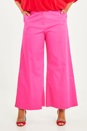 Model Noli wearing size 14 of the Wide Leg Pant in colour Hotpink (Pink), from the front, cropped image