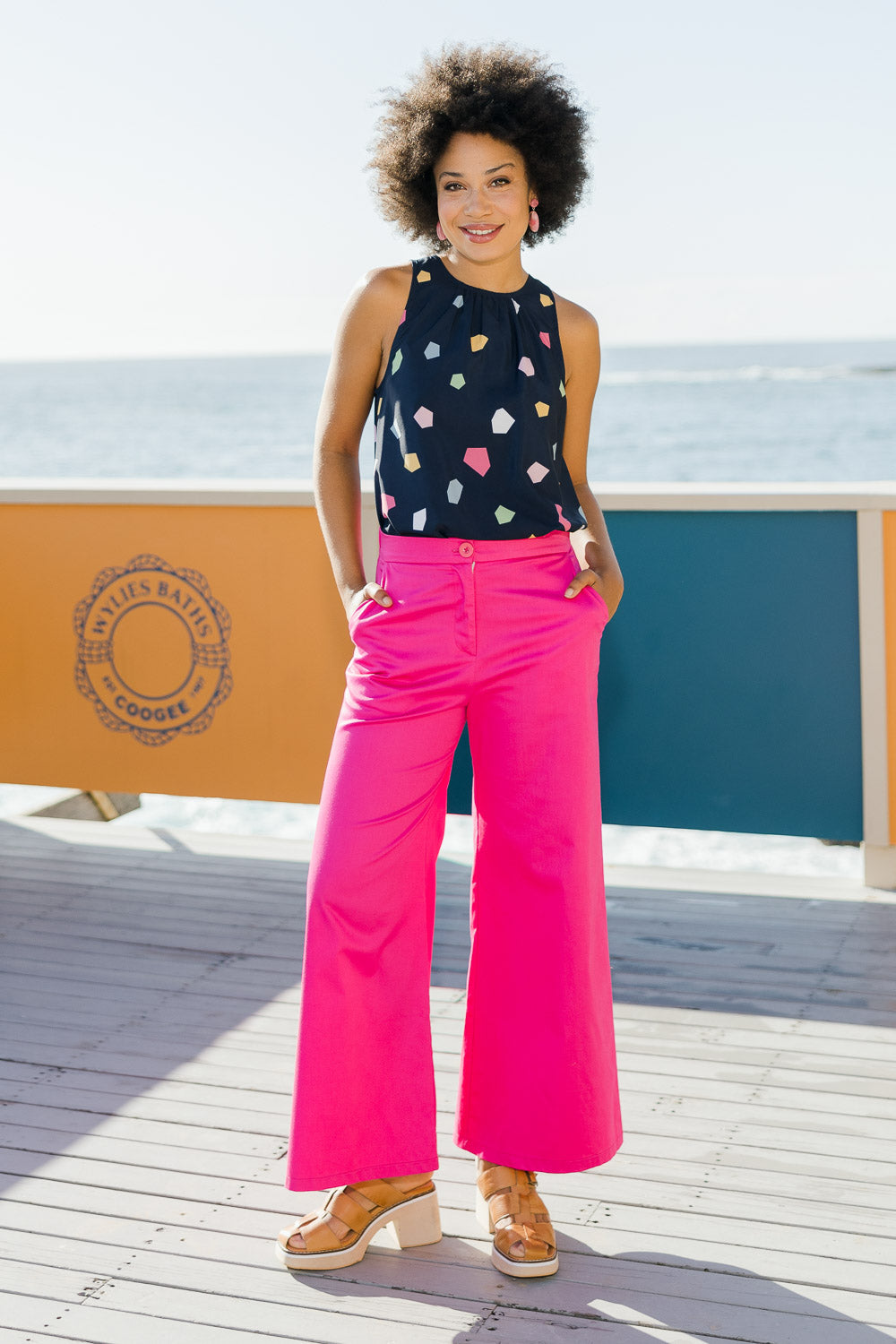 Model Olivia wearing size 10 of the Wide Leg Pant in colour Hotpink (Pink), from the front, showing the whole outfit