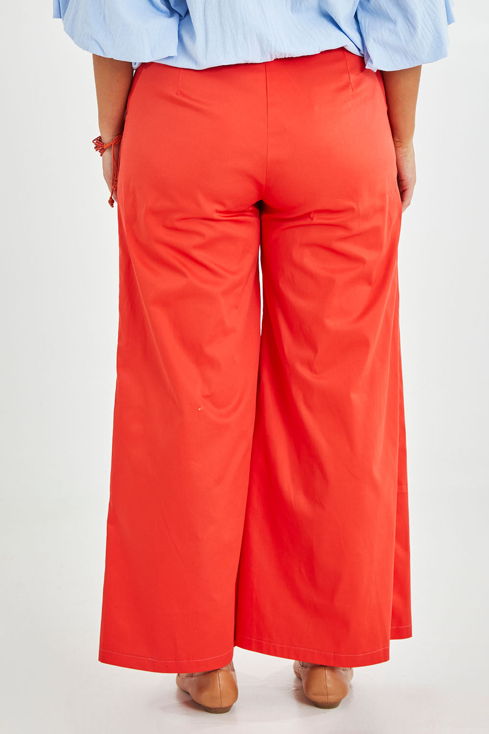 Model Monique wearing size 14 of the Wide Leg Pant in colour Rust, from the back