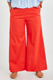 Model Monique wearing size 14 of the Wide Leg Pant in colour Rust, from the front, cropped image