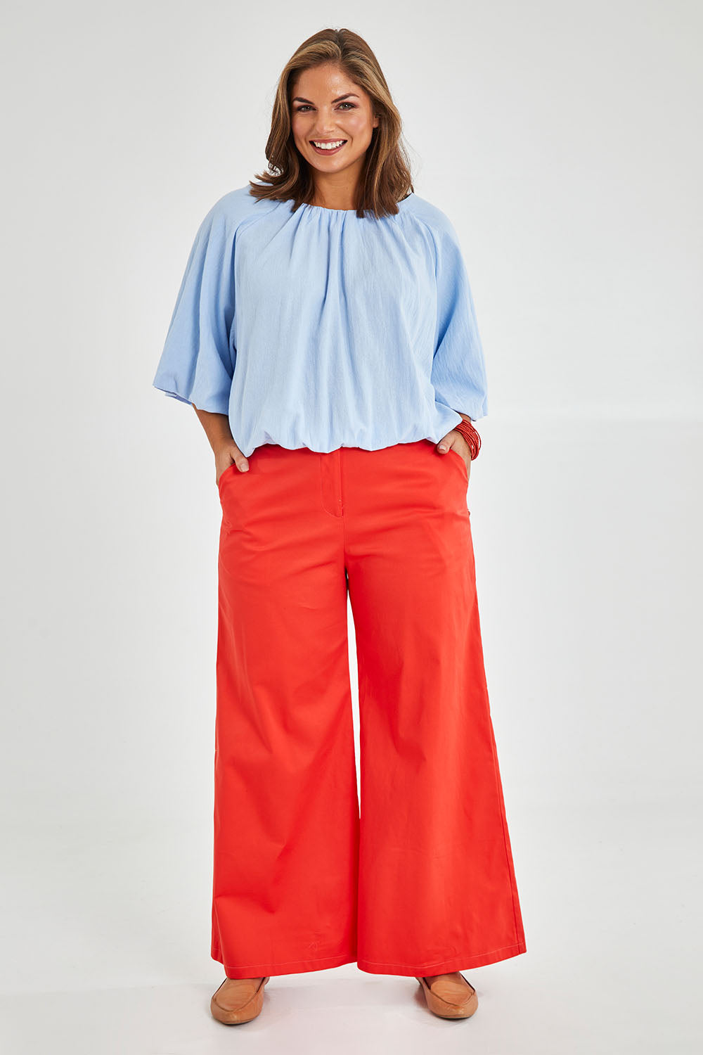 Model Monique wearing size 14 of the Wide Leg Pant in colour Rust, from the front, showing the whole outfit