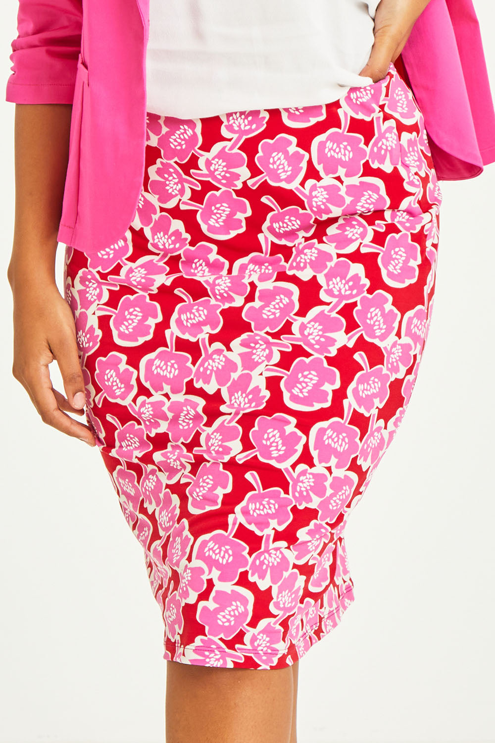 Model Noli wearing size 14 of the Printed Tube Skirt in colour Roses (Red), from the front, cropped image