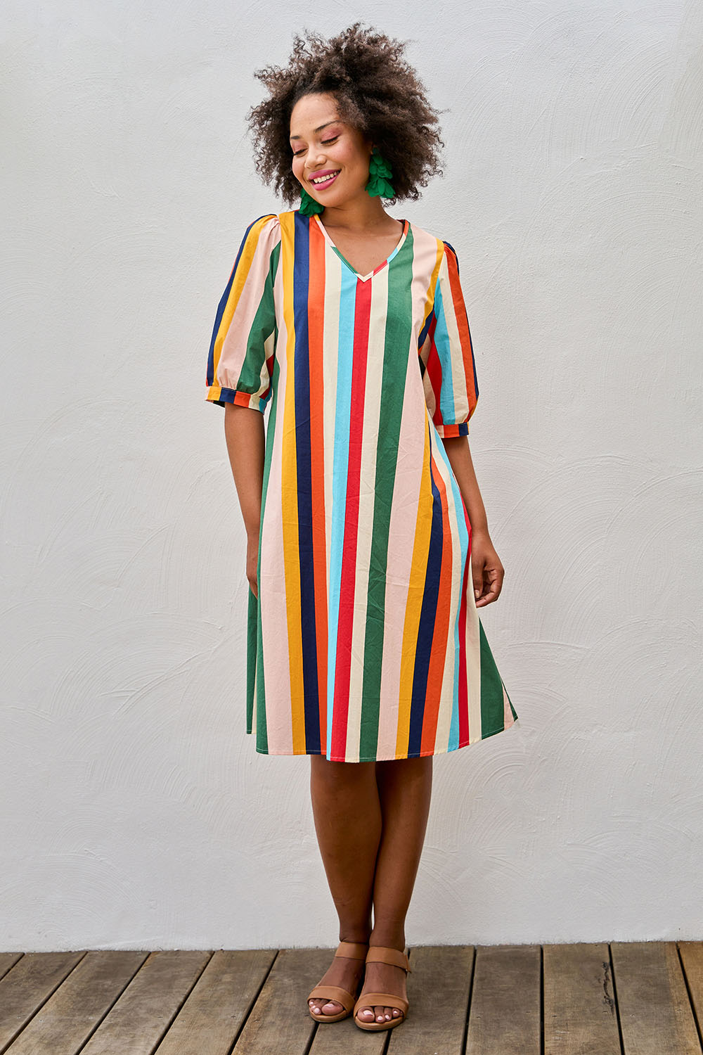 Model Olivia wearing size 10 of the V Neck Flounce Sleeve Dress in colour Striped (Blue), from the front, showing the whole outfit