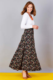 Model Riina wearing size 10 of the Printed Maxi Skirt in colour BlackFluer (Black), from the front, showing the whole outfit