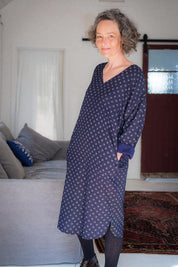A model wearing the Amelia Dress in colour Elsie (Blue), from the front, showing the whole outfit