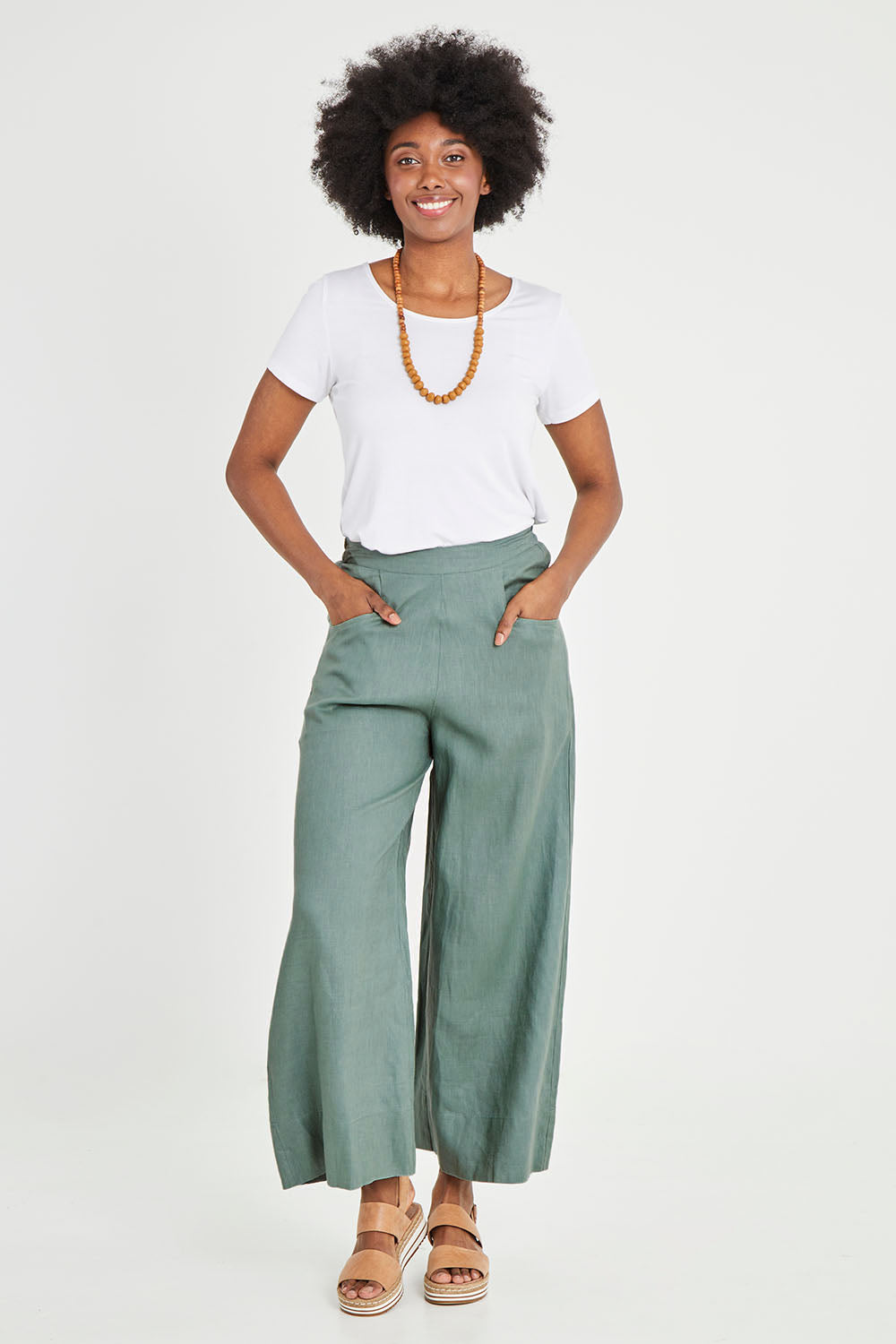 Model Aiyana wearing size S of the Ollie Pant in colour Eucalyptus (Green), from the front, showing the whole outfit