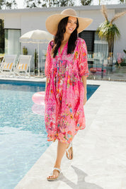 Model Stacey wearing size S of the Frankie Midi Dress in colour Melon (Pink), from the front, showing the whole outfit