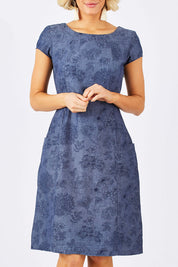 Model Emma wearing size 10 of the Victoria Dress in colour LinearFlor (Blue), from the front, cropped image