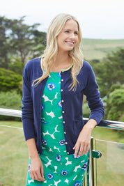 A model wearing the St Austell Dress in colour Modrnflorl (Green), from the front, showing the whole outfit