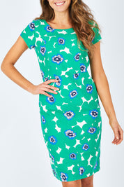 Model Madeline wearing size 10 of the St Austell Dress in colour Modrnflorl (Green), from the front, cropped image
