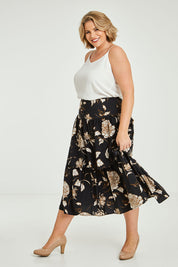 Model Fiona wearing size 16 of the Samara Skirt in colour Disbud (Black), from the front, showing the whole outfit