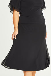 Model Palatina wearing size 16 of the Gia Skirt in colour Black (Black), from the front, cropped image
