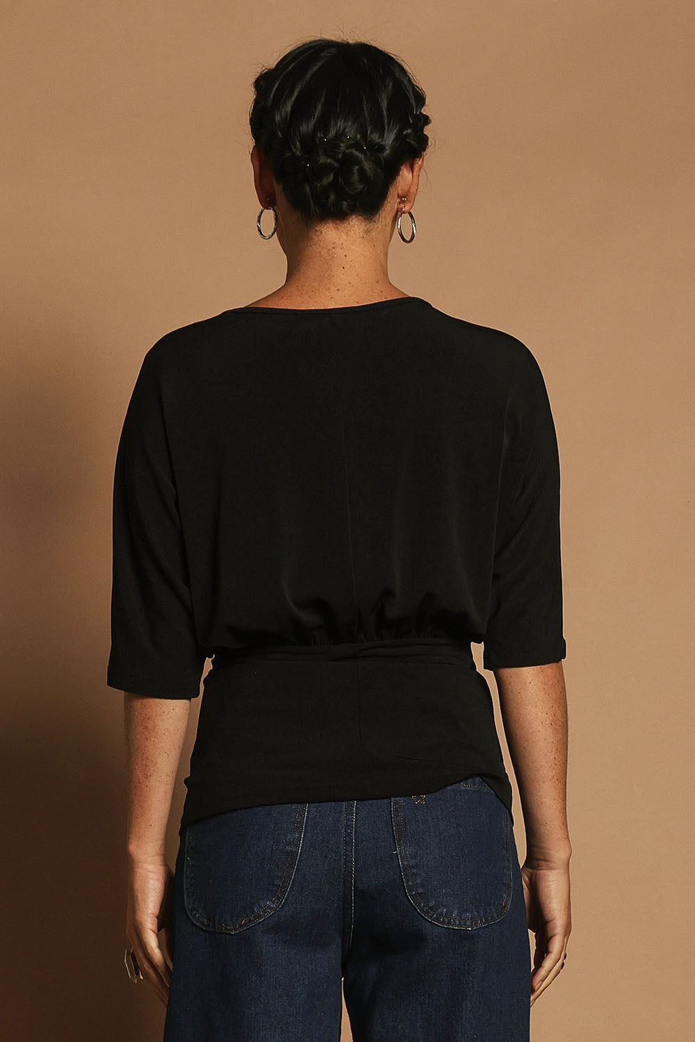 Model Katie wearing size 10 of the Niamh Top in colour Black (Black), from the back