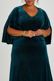 Model Alexis wearing size 16 of the Lynette Velvet Cape in colour Jade (Green), from the front, cropped image