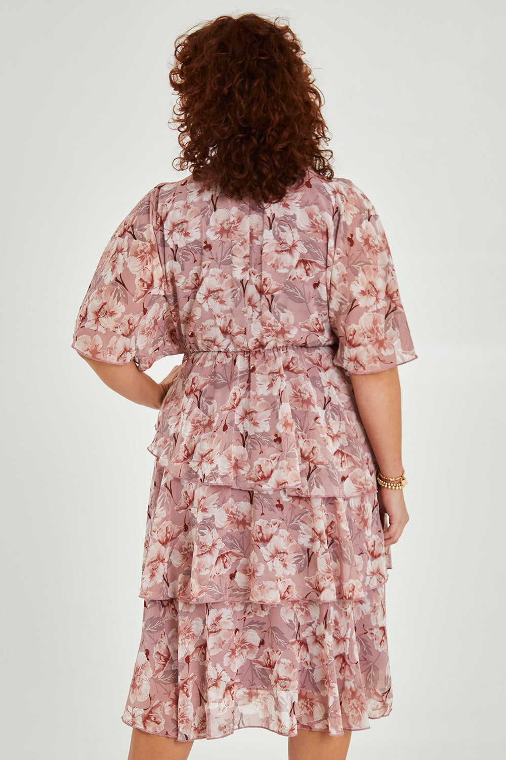 Model Maddy wearing size 16 of the Sadie Dress in colour Blushfleur (Pink), from the back