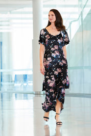 Model Anneliese wearing size 10 of the Rebecca Dress in colour WinterRose (Black), from the front, showing the whole outfit