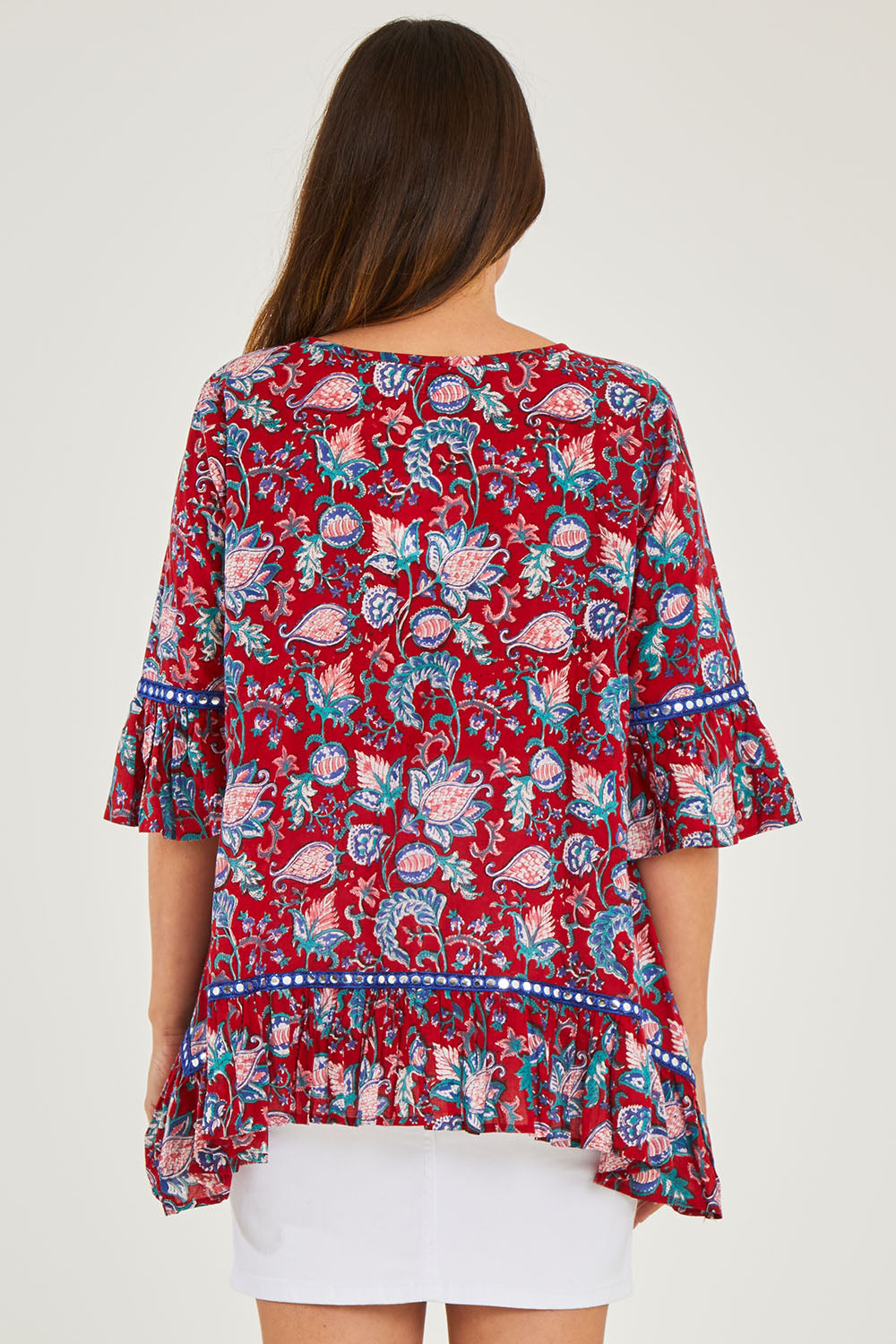 Model Georgia wearing size S of the Hacienda Tunic in colour Novellared (Red), from the back
