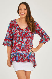 Model Georgia wearing size S of the Hacienda Tunic in colour Novellared (Red), from the front, cropped image