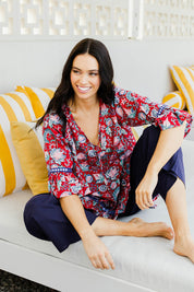 Model Stacey wearing size S of the Hacienda Tunic in colour Novellared (Red), from the front, showing the whole outfit