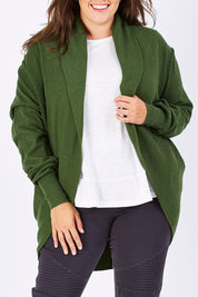 Model Mae wearing size XL of the Natural Cocoon Cardigan in colour Vineyard (Green), from the front, cropped image