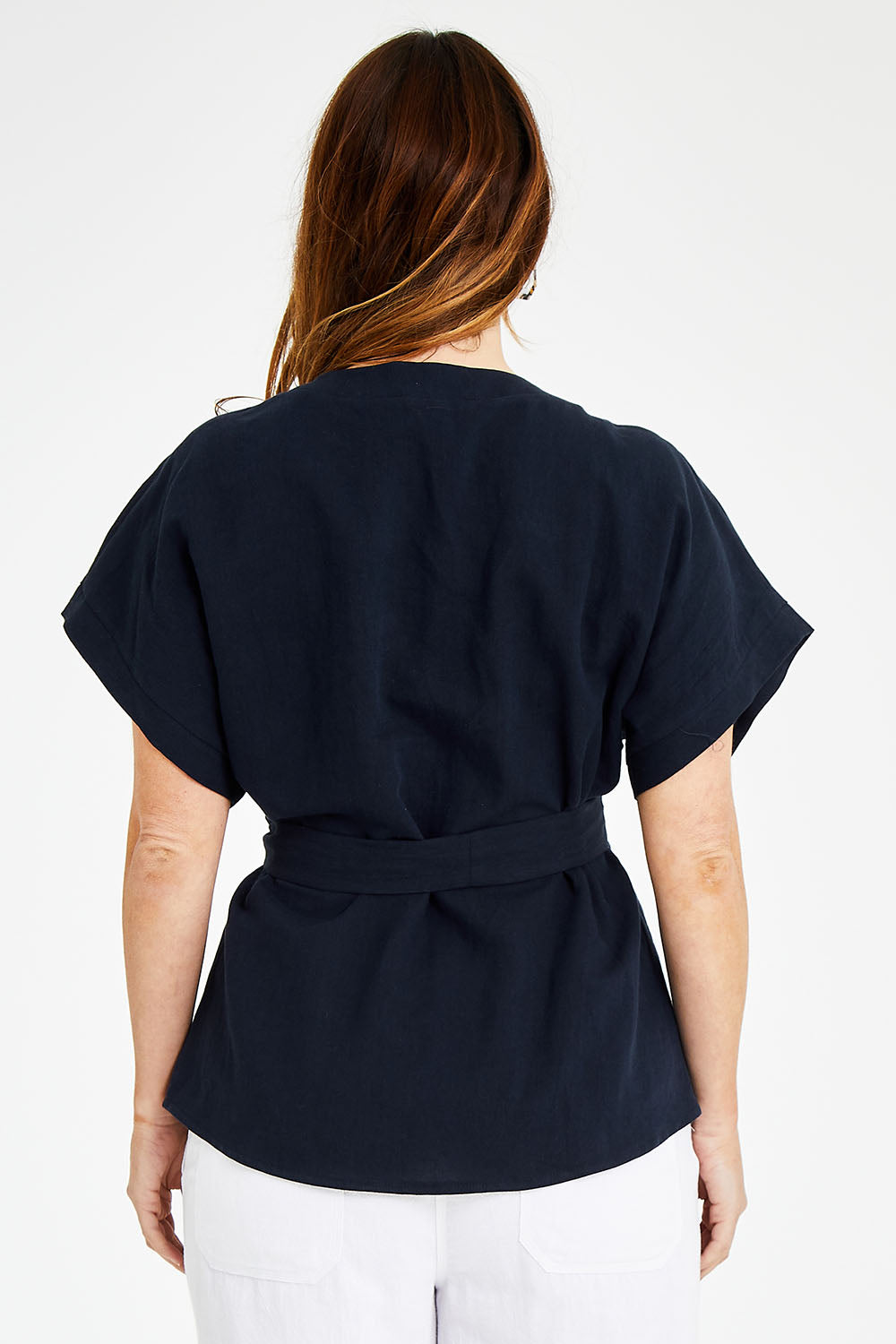 Model Laura wearing size 14 of the Linen Cotton Wrap Blouse in colour Navy (Blue), from the back