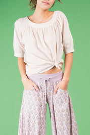 A model wearing the Bliss Top Basics in colour Mushroom, from the front, cropped image