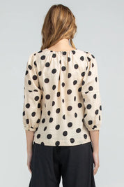 A model wearing the Lara Top in colour Whitespot (White), from the back