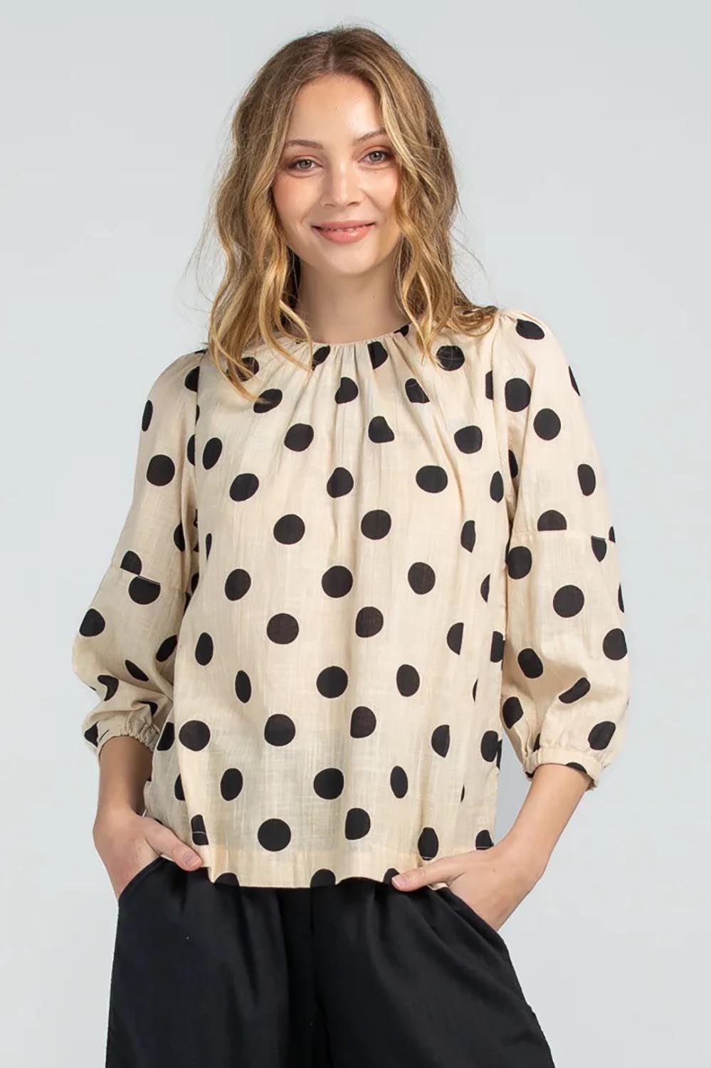 A model wearing the Lara Top in colour Whitespot (White), from the front, cropped image