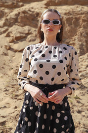 A model wearing the Lara Top in colour Whitespot (White), from the front, showing the whole outfit
