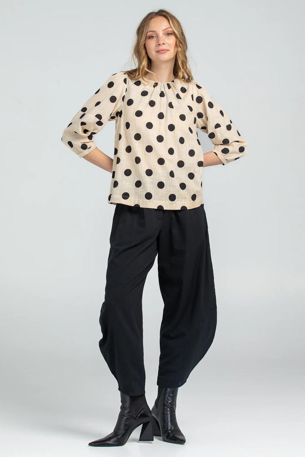 A model wearing the Lara Top in colour Whitespot (White), from the front, showing the whole outfit