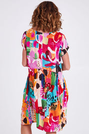 Model Emma wearing size 10 of the Alanya Short Sleeve Bubble Dress in colour Pink (Pink), from the back