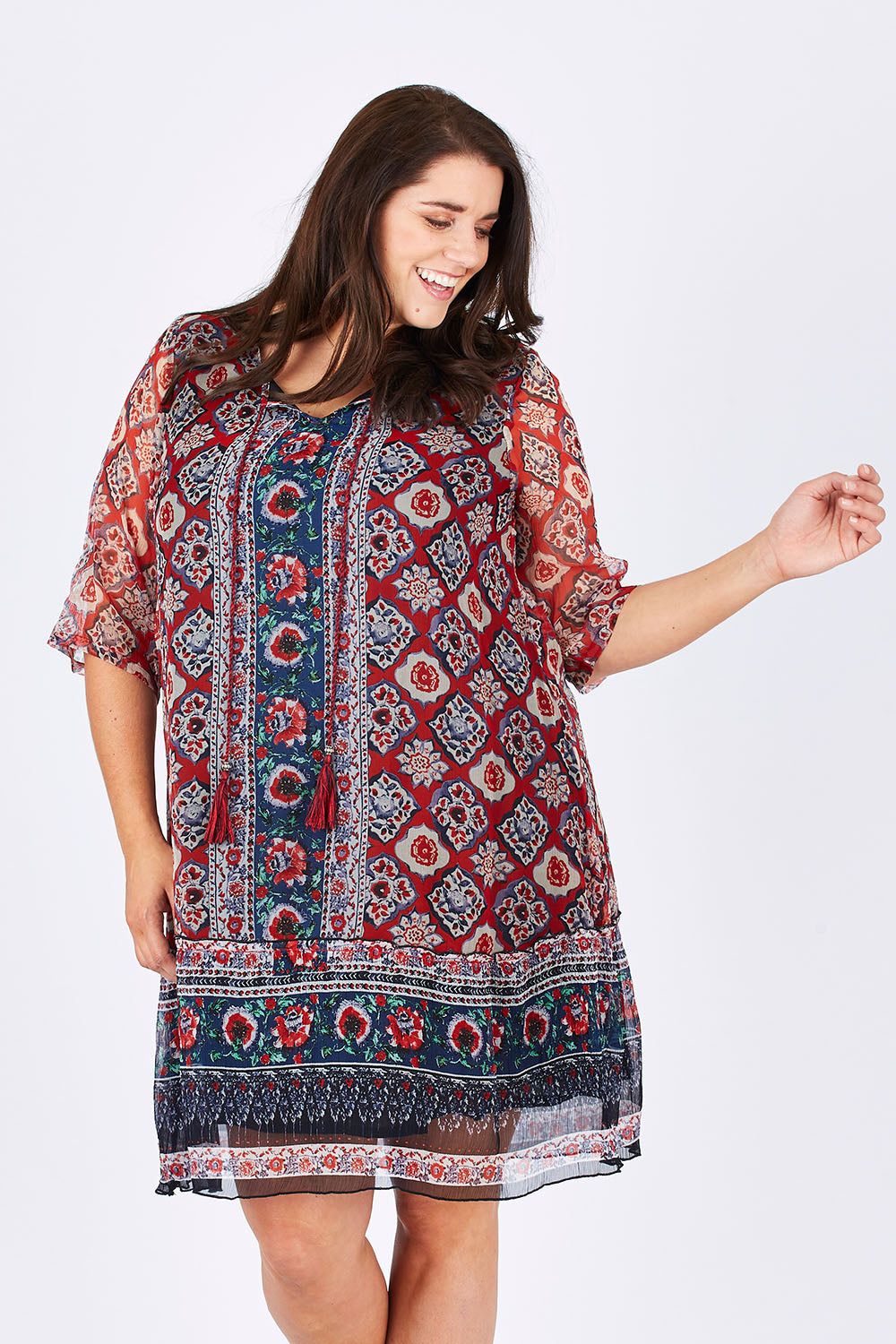 Model Mae wearing size 18 of the Urbino Print Dress in colour UrbinoPrin (Red), from the front, cropped image