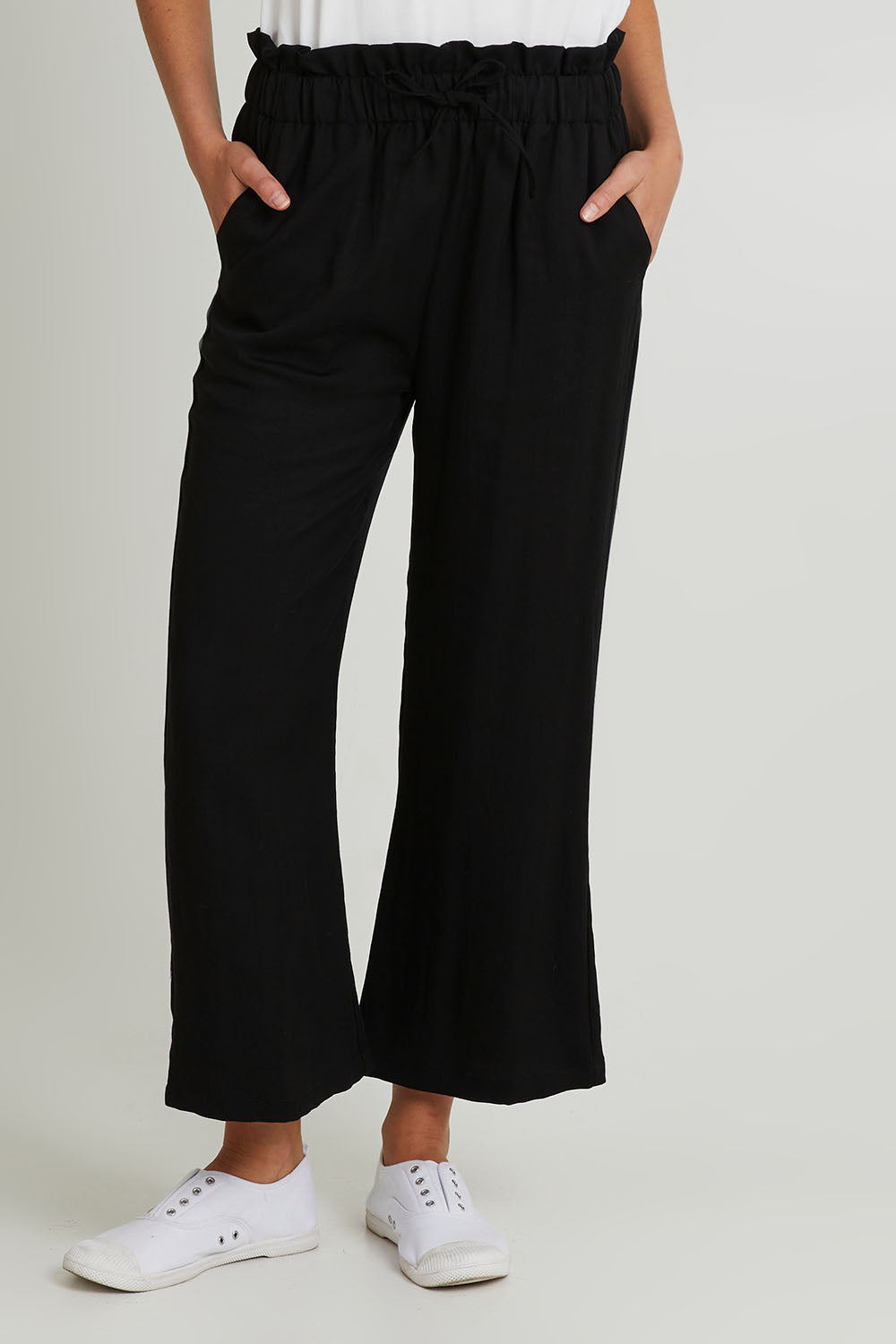 Model Madeline wearing size S of the Wide Leg Olivia Pant in colour Black (Black), from the front, cropped image