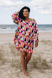 A model wearing the Sunset Gingham Tie Front Midi Dress in colour Gingham (Pink), from the front, showing the whole outfit