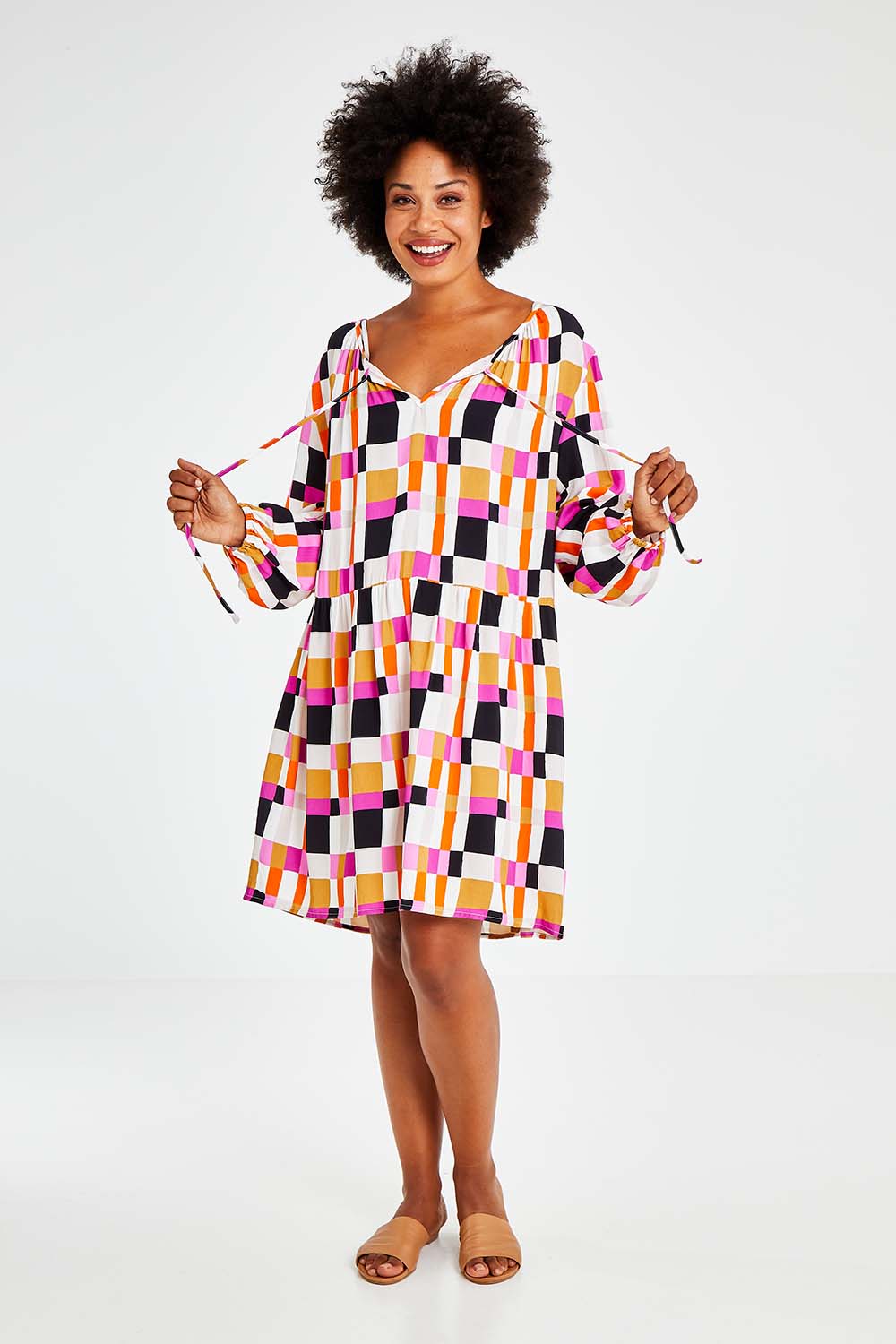 Model Olivia wearing the Sunset Gingham Tie Front Midi Dress in colour Gingham (Pink), from the front, showing the whole outfit