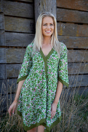 A model wearing the Libby Poncho in colour PinkFlower (Green), from the front, showing the whole outfit