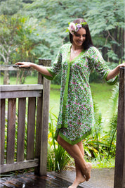 A model wearing the Libby Poncho in colour PinkFlower (Green), from the front, showing the whole outfit