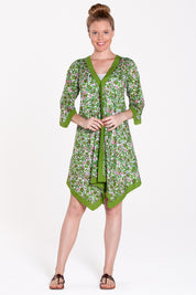 A model wearing the Libby Poncho in colour PinkFlower (Green), from the front, showing the whole outfit